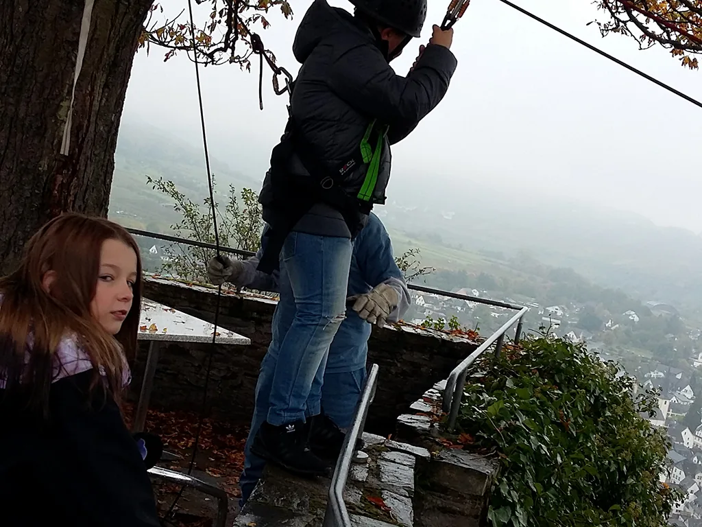 Jugendliche warten am Startpunkt der Seilrutsche.